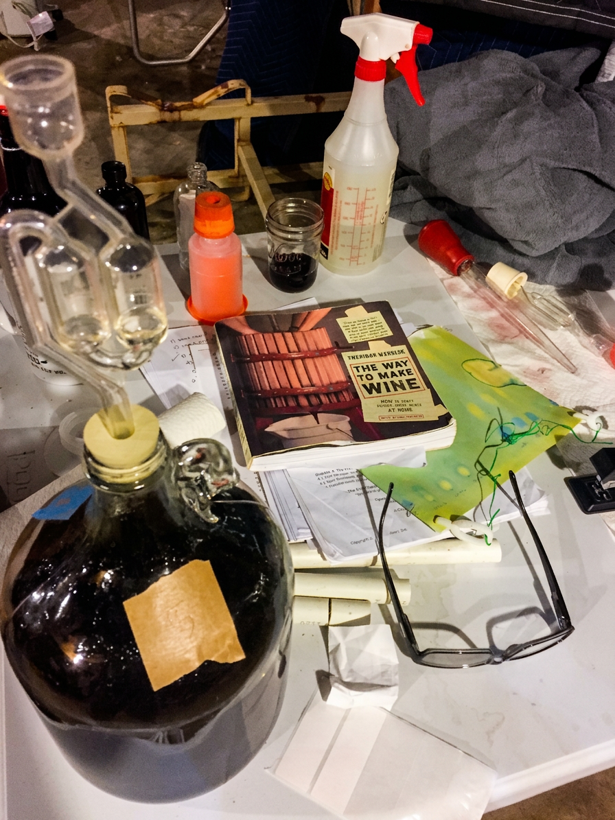 Carboy fermenting wine with airlock and notes