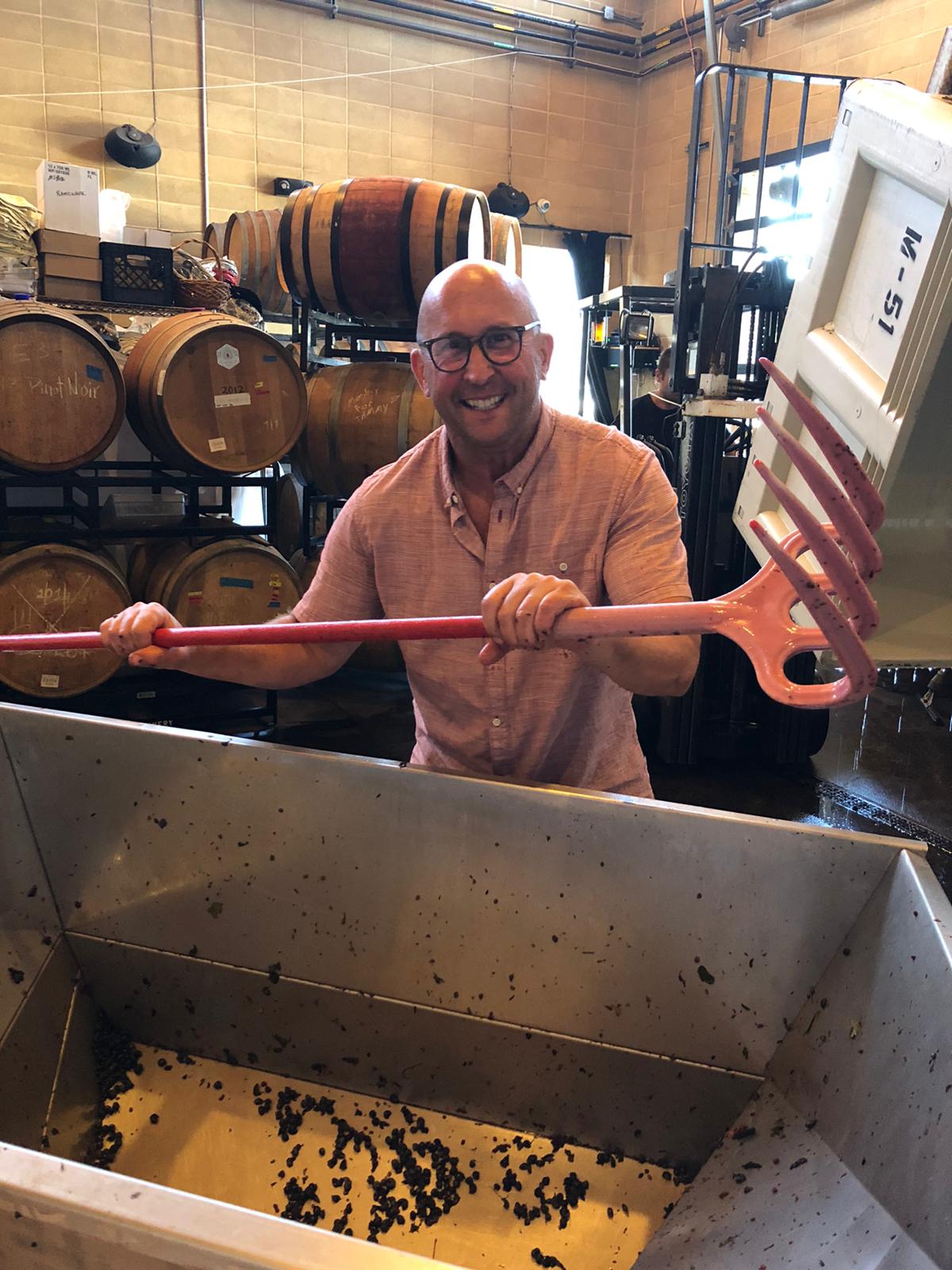 Ray punching down a tank of red wine in the cellar